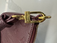 a louis vuitton purse with a gold clasp