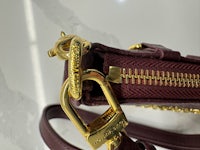 a burgundy handbag with a gold zipper
