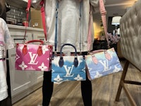 three louis vuitton handbags are on display in a room