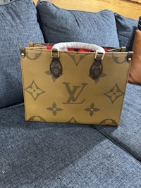 a louis vuitton briefcase sitting on a couch